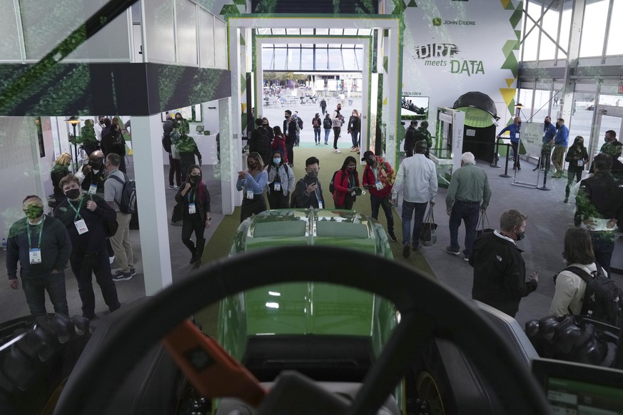 Attendees look at a John Deere automated tractor at the John Deere booth during the CES tech show Wednesday, Jan. 5, 2022, in Las Vegas. (AP Photo/Joe Buglewicz)
