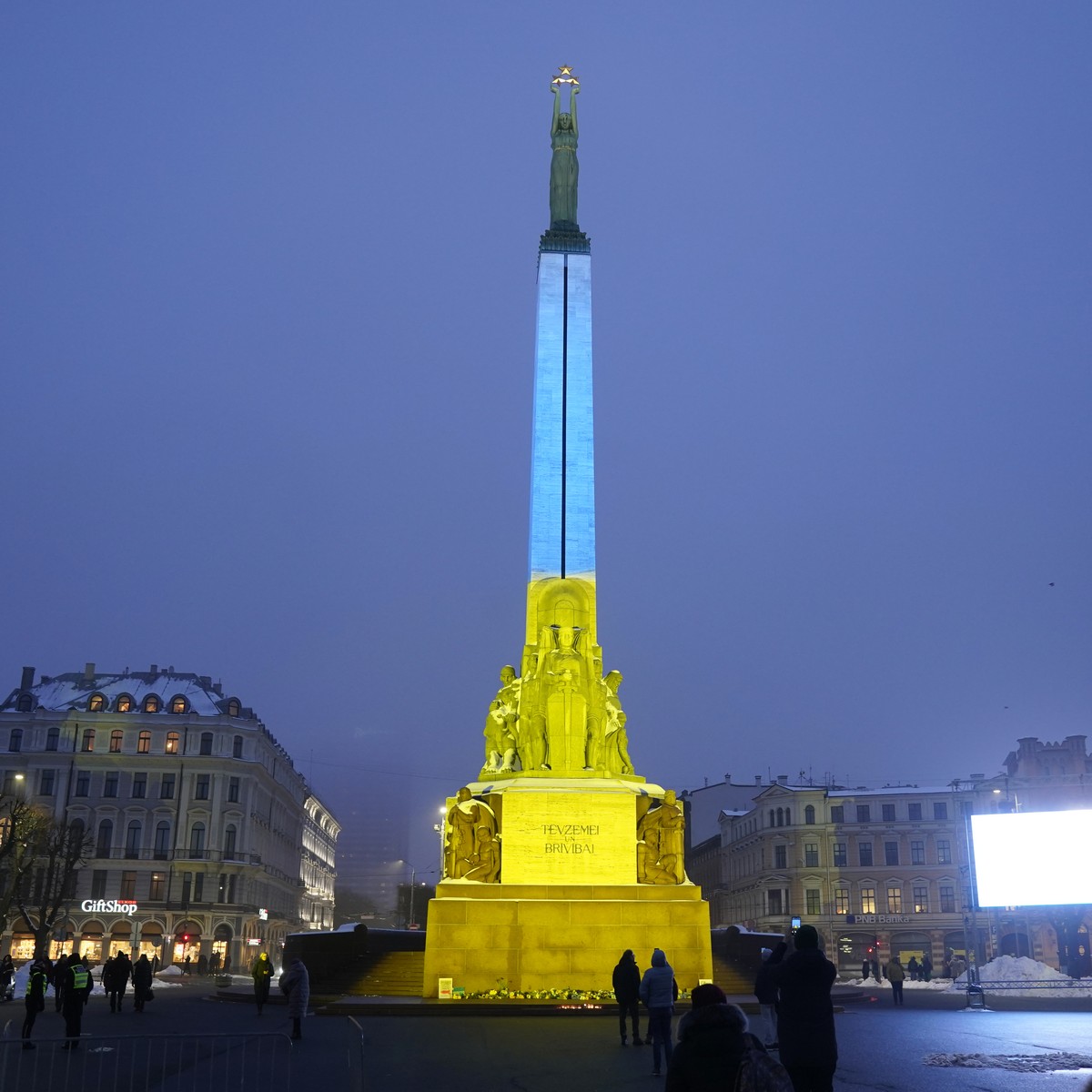 The Monument of Freedom is illuminated with the colors of the Ukrainian national flag to mark the one-year anniversary of Russia's invasion of the country, in Riga, Latvia, Friday, Feb. 24, 2023. ...