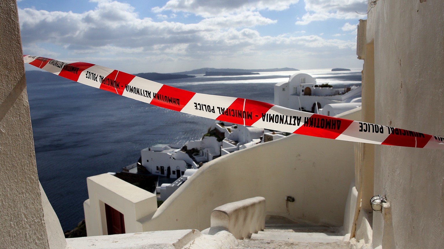 epa11876573 A cordon in a small street over the cliffs of the volcanic caldera of the almost evacuated village of Oia on Santorini island, Greece, 05 February 2025. Due to a wave of seismic activity n ...