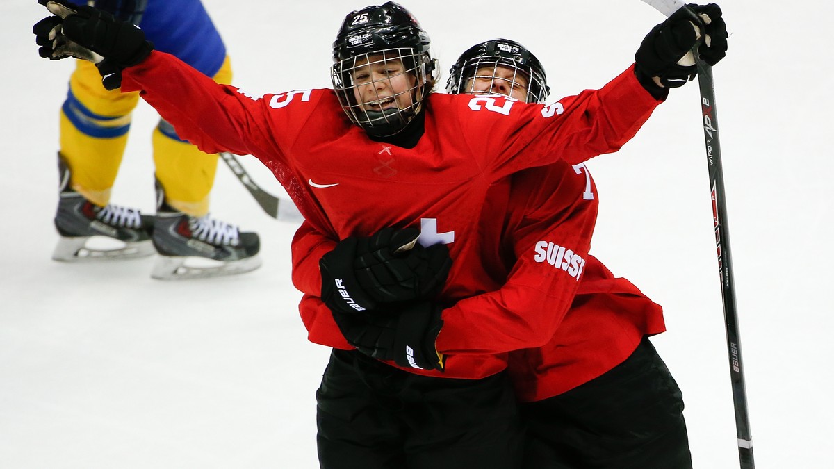 Alina Muller of Switzerland (25) is hugged by Lara Stalder of Switzerland (7) after scoring against Sweden during the third period of the women's bronze medal ice hockey game at the 2014 Winter O ...