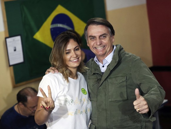 Jair Bolsonaro, presidential candidate with the Social Liberal Party, and his wife Michelle pose for photos during the presidential runoff election in Rio de Janeiro, Brazil, Sunday, Oct. 28, 2018. Ja ...