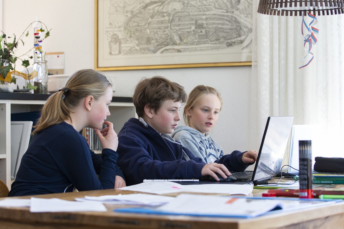 Ellie, Saemi und Thommy, von links, machen ihre Schulaufgaben waehrend der Coronavirus Pandemie zuhause im Wohnzimmer, am Dienstag, 31. Maerz 2020 in Jegenstorf. (KEYSTONE/Peter Klaunzer)