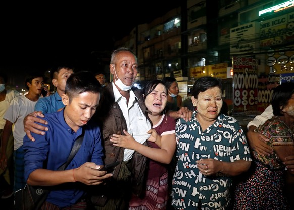 epa09530203 A released man (2-L) meets with his family members outside the Insein prison in Yangon, Myanmar, 18 October 2021. Myanmar&#039;s junta chief Min Aung Haling announced the released of over  ...