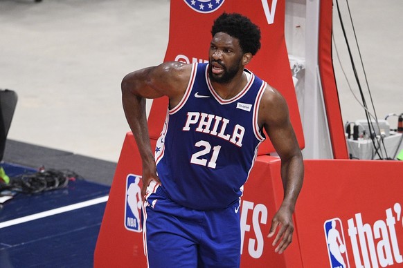 Philadelphia 76ers center Joel Embiid (21) touches his right side after he fell on the court during the first half of Game 4 in a first-round NBA basketball playoff series against the Washington Wizar ...
