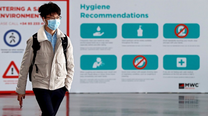 epa08200395 A worker using a mask leaves the Mobile World Congress&#039; facilities in Barcelona, Spain, 07 February 2020. Ericsson and LG announced that they will not attend the Mobile World Congress ...