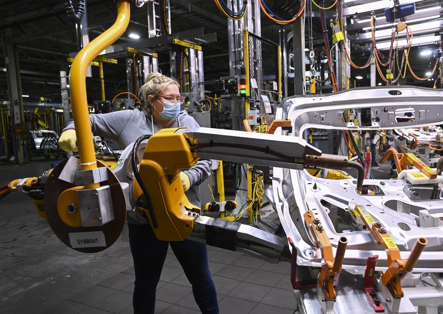 GM workers use human assistance automation to weld vehicle doors at the General Motors assembly plant during the COVID-19 pandemic in Oshawa, Ontario, Friday, March 19, 2021. (Nathan Denette/The Canad ...