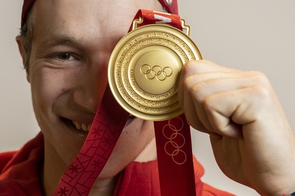 Olympia Goldmedaillengewinner Marco Odermatt posiert bei seiner Ankunft am Flughafen Zuerich mit seiner Goldmedaille, aufgenommen am Dienstag, 15. Februar 2022 in Zuerich Kloten.(KEYSTONE/Ennio Leanza ...