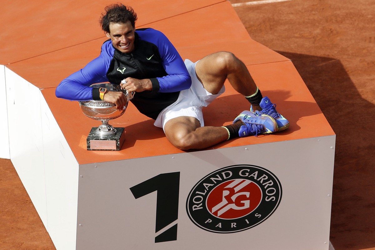 FILE - The logo on the podium was altered to read 10 as Spain's Rafael Nadal holds the trophy after winning his tenth French Open title against Switzerland's Stan Wawrinka in the men's  ...