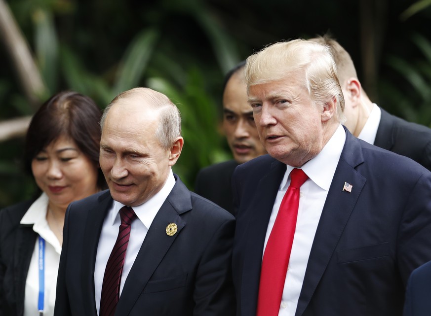 U.S. President Donald Trump, right, and Russia&#039;s President Vladimir Putin, center, talk during the family photo session at the APEC Summit in Danang, Saturday, Nov. 11, 2017. Trump and Putin chat ...