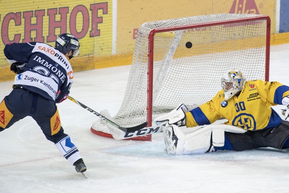 Der Zuger Jarkko Immonen, links, schiesst das 1:0 gegen den Davoser Torhueter Joren van Pottelberghe, rechts, beim Eishockey Meisterschaftsspiel zwischen dem EV Zug und dem HC Davos, am Samstag, 17. S ...