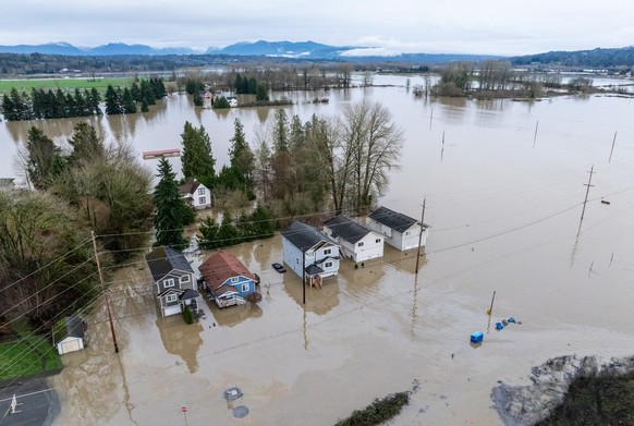 An aerial view shows homes surrounded by floodwaters in Snohomish, Wash., Thursday, Dec. 11, 2025. (AP Photo/Stephen Brashear)