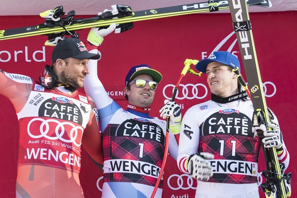 Aksel Lund Svindal from Norway, second place, Beat Feuz from Switzerland, winner, and Matthias Mayer from Austria, third place, from left, celebrate during the flower ceremony in the finish area after ...