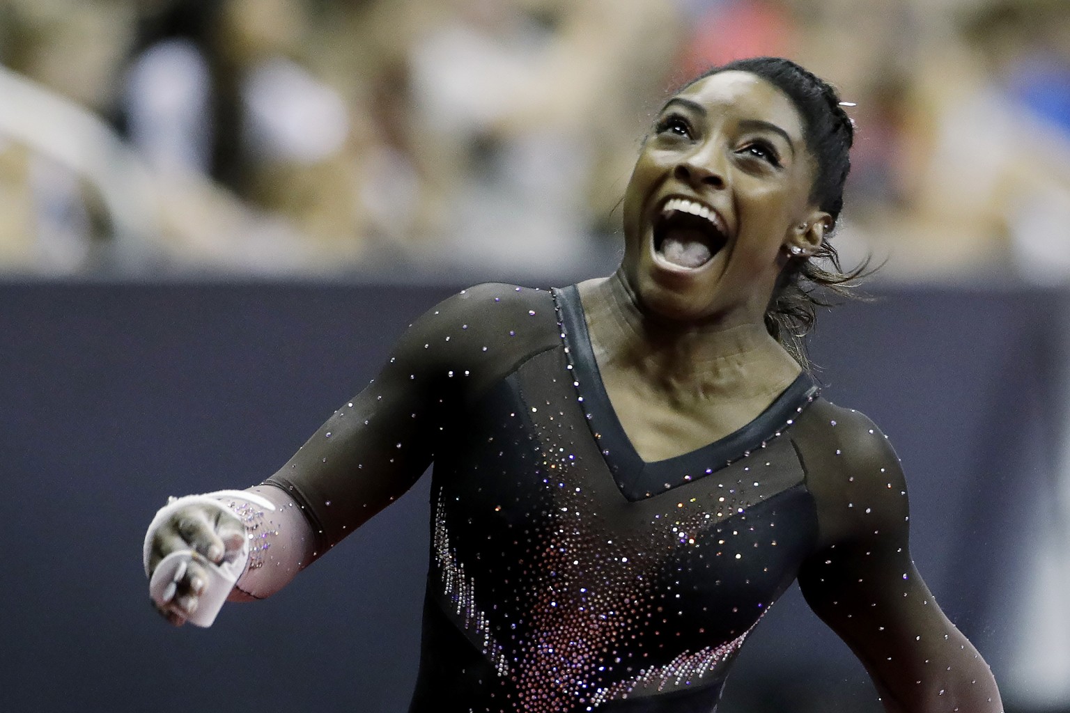 Simone Biles celebrates after competing in the uneven bars to win the all around senior women&#039;s competition at the 2019 U.S. Gymnastics Championships Sunday, Aug. 11, 2019, in Kansas City, Mo. (A ...