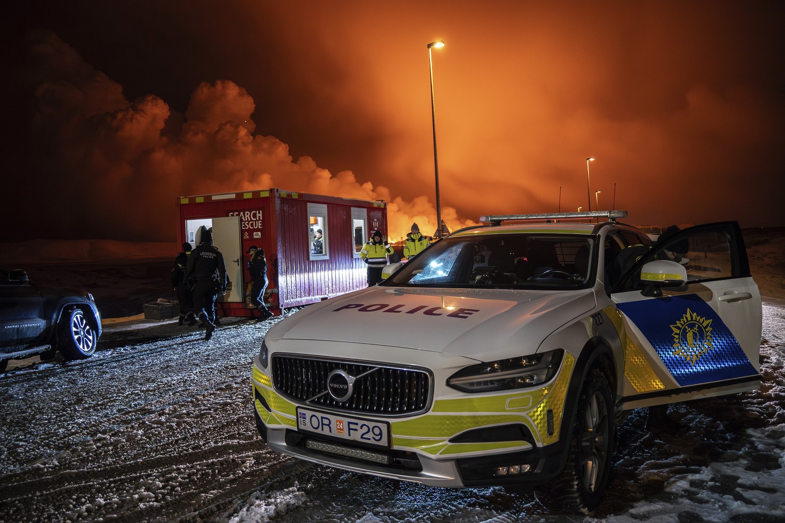 The police vehicle is parked at the entrance of the road to Grindav�k with the eruption in the background, near Grindavik on Iceland&#039;s Reykjanes Peninsula, Monday, Dec. 18, 2023. A volcanic erupt ...