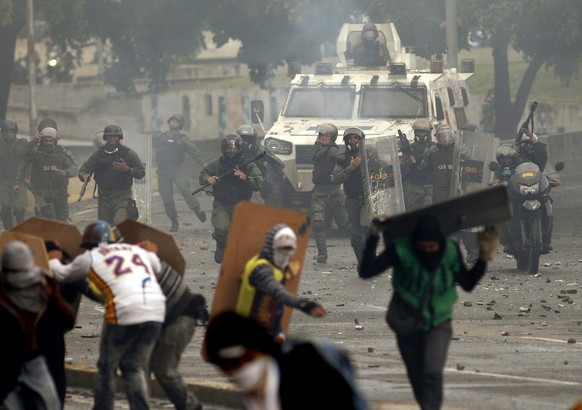 Bolivarian National Guards charge on anti-government demonstrators in Caracas, Venezuela, Friday, July 28, 2017, two days before the vote to begin the rewriting of Venezuela&#039;s constitution. Prote ...