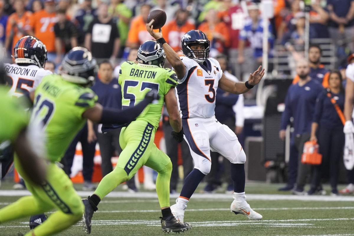 Denver Broncos quarterback Russell Wilson (3) passes under pressure from Seattle Seahawks linebacker Cody Barton (57) during the second half of an NFL football game, Monday, Sept. 12, 2022, in Seattle ...