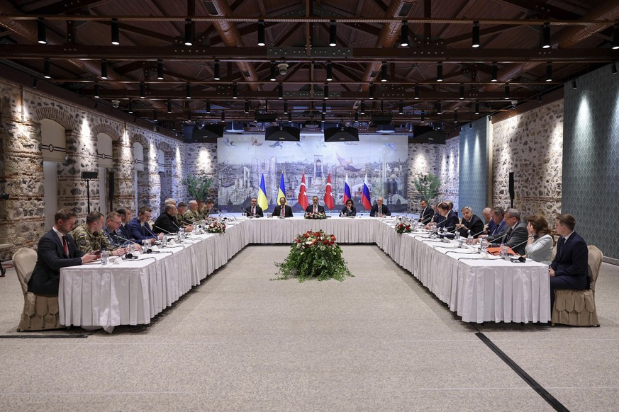 In this handout photo released by Turkish Foreign Ministry, Turkish Foreign Minister Hakan Fidan, center, chairs a meeting between delegations from Russia, right, and Ukraine, left, at Dolmabahce pala ...