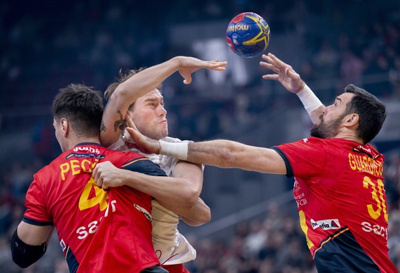 epa10434713 Denmark's Simon Pytlick is tackled by Spain's Ignacio Pecina Tome (L) and Gedeon Guardiola Villaplana during the IHF Men's Handball World Championship semifinal match between Spain and Den ...