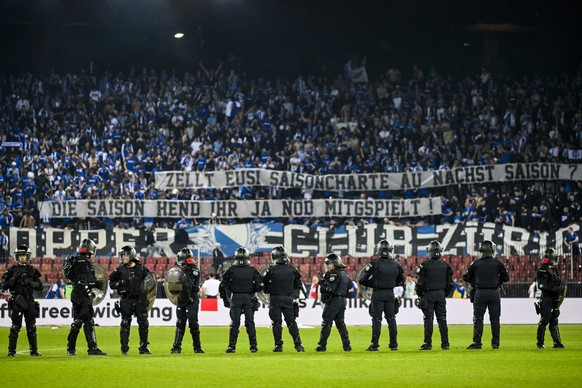 Polizisten stehen auf dem Rasen, im Hintergrund ein Transparent mit Kritik der GC Fans an ihrer Mannschaft, beim Super League/Challenge League Barrage Rueckspiel zwischen dem Grasshopper Club Zuerich  ...