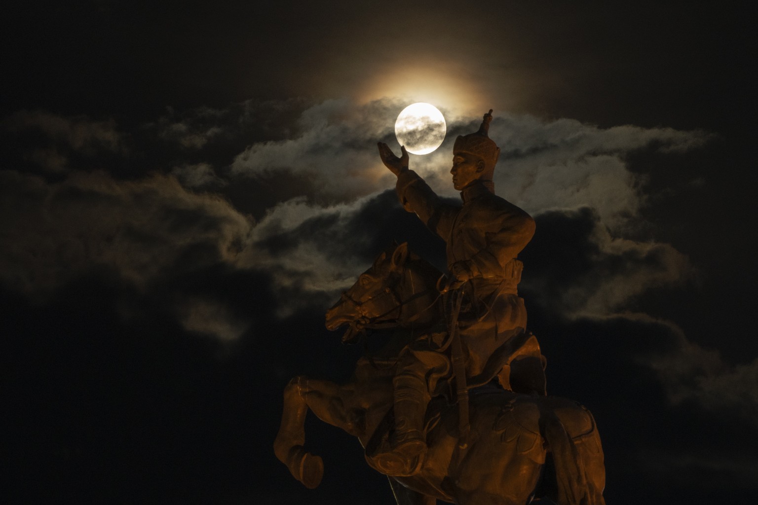 The supermoon rises near the equestrian statue of Damdin Sukhbaatar on Sukhbaatar Square in Ulaanbaatar, Mongolia, on Wednesday, Aug. 30, 2023. August 30 sees the month's second supermoon, when a ...