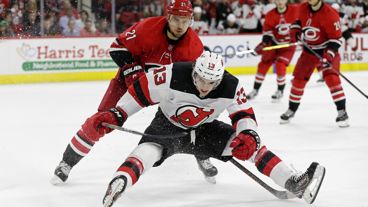 Carolina Hurricanes' Nino Niederreiter (21), of the Czech Republic, and New Jersey Devils' Nico Hischier (13), of Switzerland, chase the puck during the second period of an NHL hockey game i ...