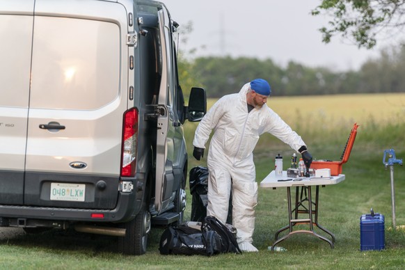 An investigator in protective equipment works at a crime scene in Weldon, Saskatchewan, on Sunday, Sept. 4, 2022. Saskatchewan RCMP has confirmed that there are 10 dead while 15 are injured following  ...