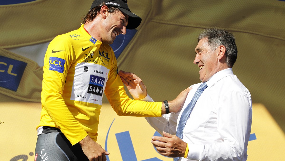 Fabian Cancellara of Switzerland, wearing the overall leader's yellow jersey, left, and Belgium cyclist and Tour de France winner Eddy Merckx, right, react on the podium after the first stage of  ...