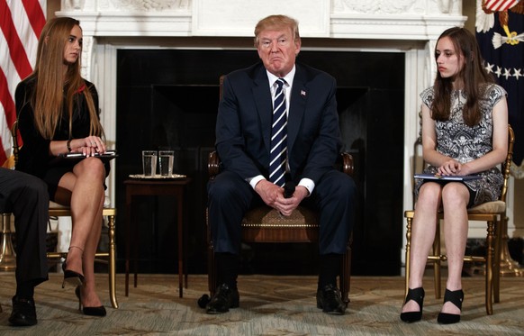 President Donald Trump, joined by Marjory Stoneman Douglas High School student Carson Abt, right, and Julia Cordover, the student body president at Marjory Stoneman Douglas High School, left, pauses d ...