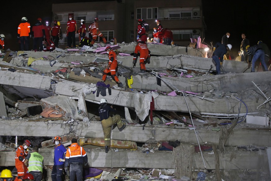 Members of rescue services search in the debris of a collapsed building for survivors in Izmir, Turkey, early Saturday, Oct. 31, 2020. A strong earthquake struck Friday in the Aegean Sea between the T ...