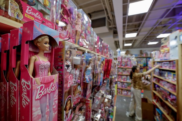 epa12079011 Independent toy store owner Ming 'Yaya' Yang restocks her inventory of Mattel-made Barbie products at Richard's Variety Store ahead of price hikes due to expected tariffs in ...