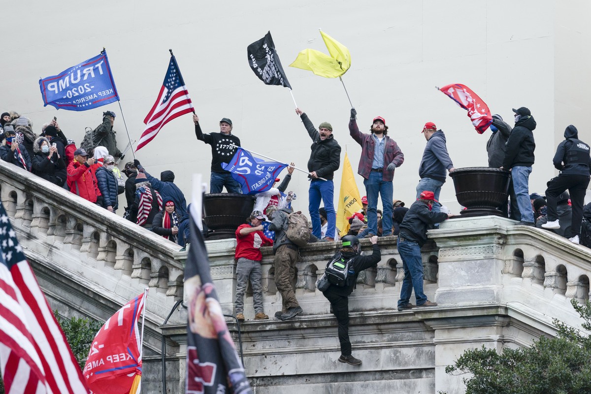 FILE - Rioters wave flags on the West Front of the U.S. Capitol in Washington on Jan. 6, 2021. Federal prosecutors say a network of supporters has helped fugitives from Florida avoid capture to face c ...