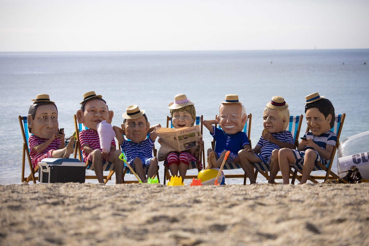 epaselect epa09264502 Oxfam campaigners wearing costumes depicting G7 leaders pose for photographers on Swanpool Beach near Falmouth, Cornwall, Britain 12 June 2021. Britain is hosting the G7 summit i ...