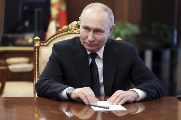 Russian President Vladimir Putin speaks to Rector of the Lomonosov Moscow State University Viktor Sadovnichy after congratulating him on his 85th birthday during their meeting at the Kremlin in Moscow ...