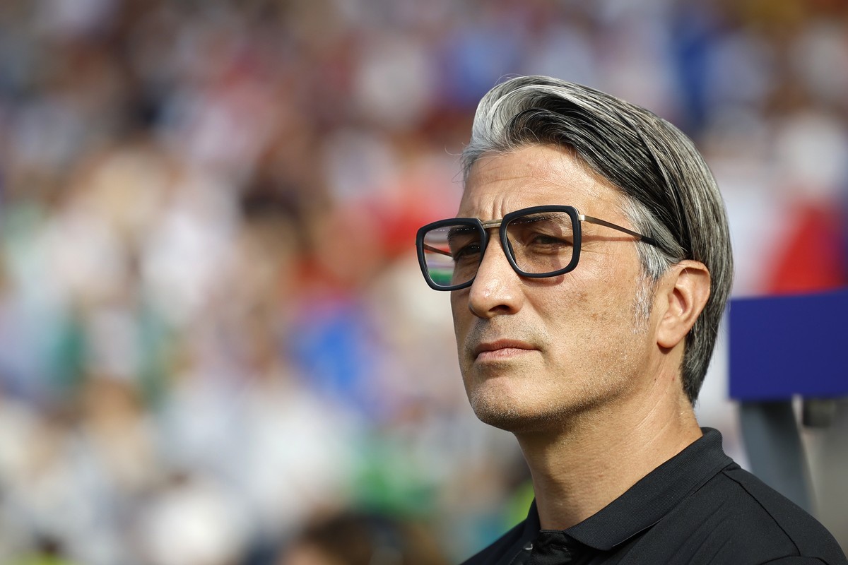 Switzerland's head coach Murat Yakin has his sunglasses on while listening to the national anthems prior to a round of 16 match between Switzerland and Italy at the Euro 2024 soccer tournament in ...