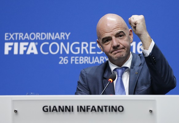 FILE - In this Friday, Feb. 26, 2016 file photo, newly elected FIFA president Gianni Infantino of Switzerland as he raises an arm during a press conference after the second election round during the e ...