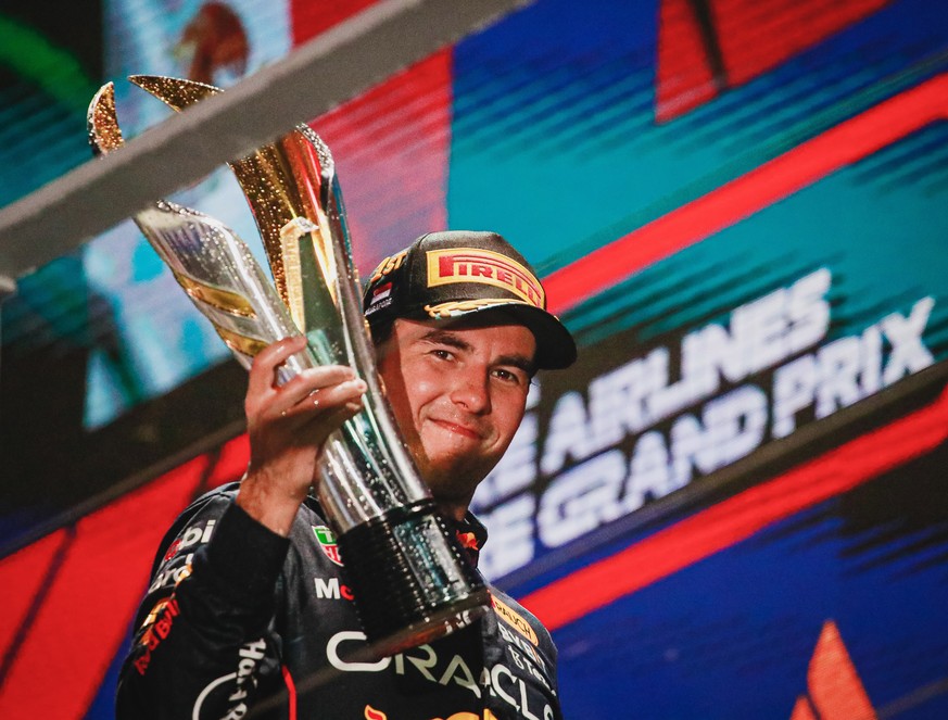 epa10219793 First placed Mexican Formula One driver Sergio Perez of Red Bull Racing holds his trophy on the podium after the Singapore Formula One Grand Prix race at the Marina Bay Street Circuit, Sin ...