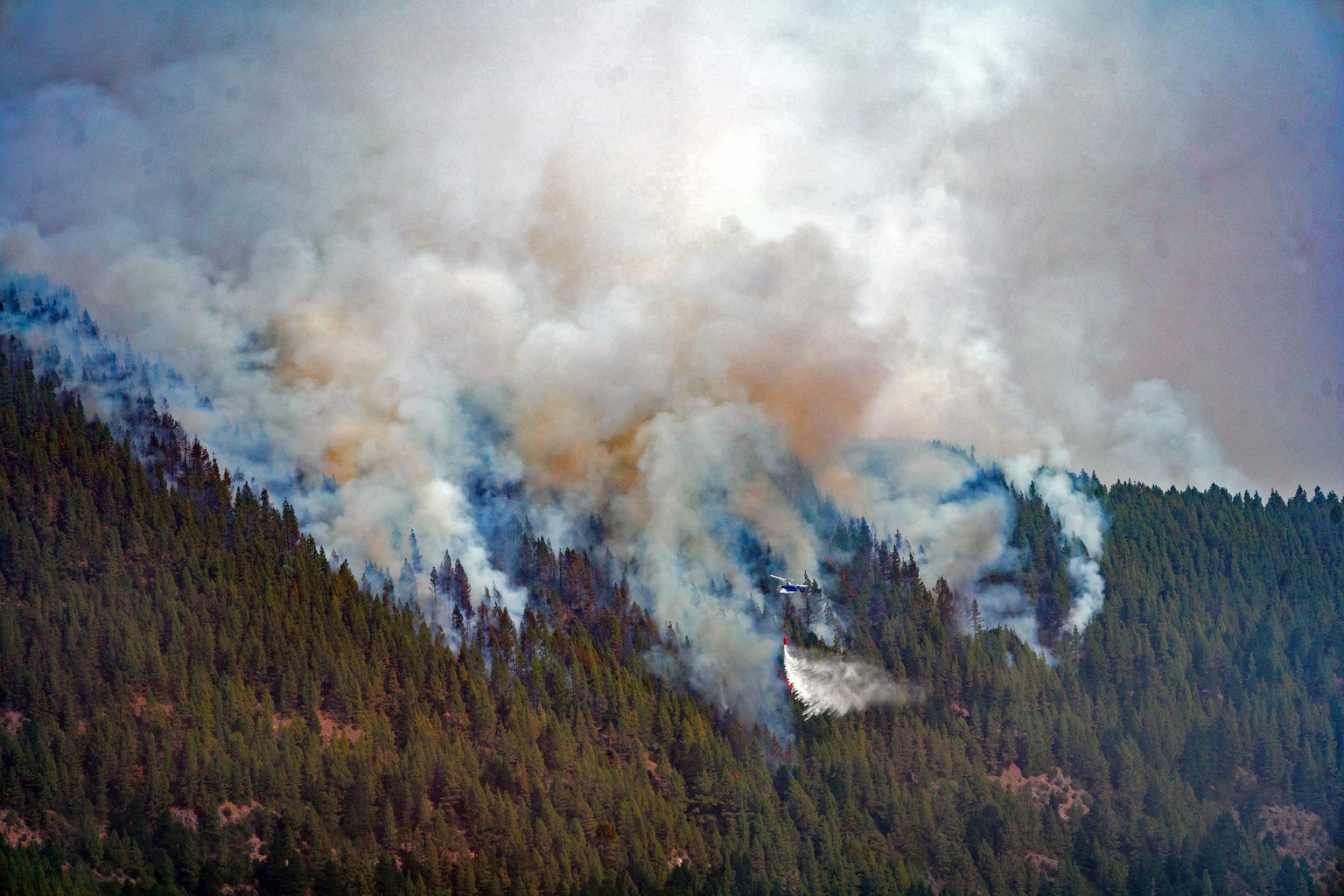 epaselect epa10087652 A helicopter drops water to extingish the forest fire in La Orotava, Tenerife, Canary Island, Spain, 23 July 2023. The forest fire started on 21 July and reportedly has already b ...