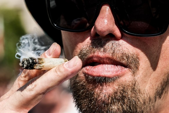 epa12291095 A participant smokes cannabis during the Hemp Parade (Hanfparade) rally in Berlin, Germany, 09 August 2025. The annual pro-cannabis protest is Germany's largest demonstration for the  ...