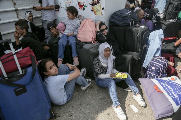 epa10921856 Palestinians with dual nationalities wait to cross the Rafah border crossing with Egypt, southern Gaza Strip, 16 October 2023. Israel has warned all citizens of the Gaza strip to move to t ...