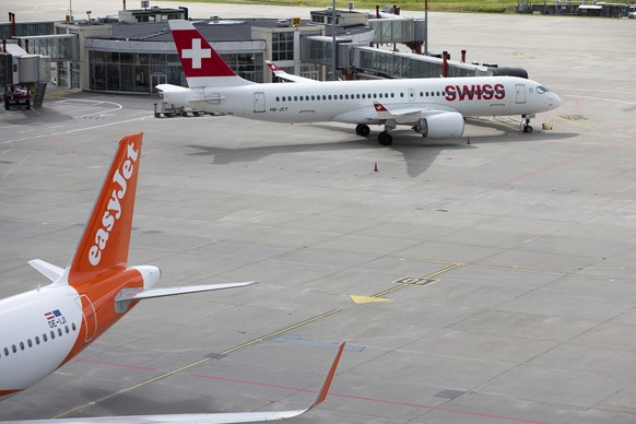 Un avion Airbus A320-214 (OE-IJI) d&#039; easyJet et un avion Airbus A220-300 (HB-JCT) de Swiss International Air Lines sont stationnes sur le tarmac de Geneve Aeroport, ce lundi 7 juin 2021 a Geneve. ...