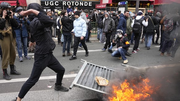 A youth throws an item on police forces during a demonstration Thursday, April 6, 2023 in Paris. Hundreds of thousands of people are expected to fill the streets of France Thursday for the 11th day of ...