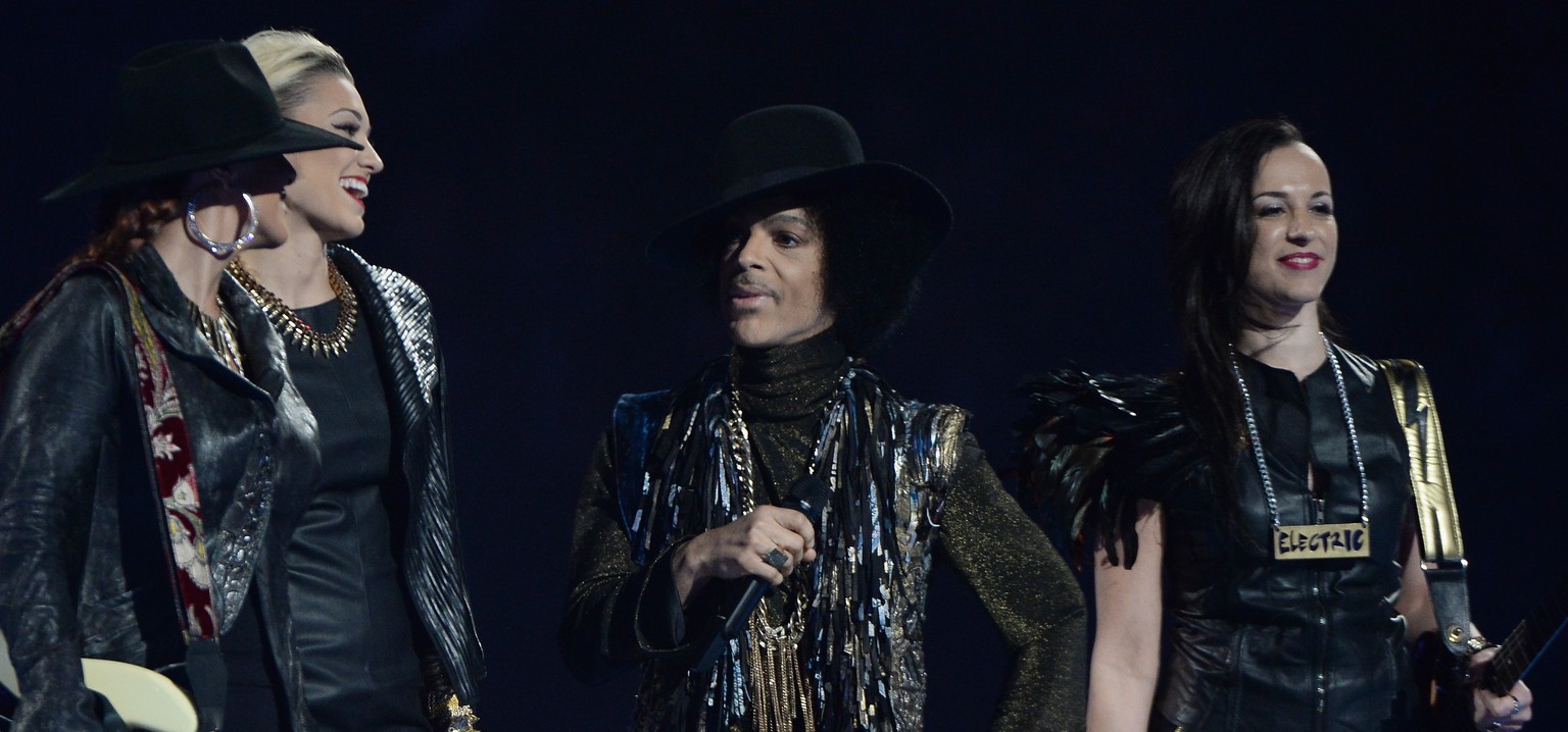 Prince flankiert von Mitgliedern seiner aktuellen Band, 3rd Eye Girl an den Brit Awards im Februar 2014.