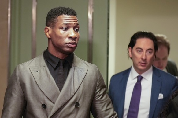 Jonathan Majors, left, enters a courtroom at the Manhattan criminal courts in New York, Monday, Dec. 18, 2023. The actor is accused of assaulting his then-girlfriend as the two struggled over a phone  ...