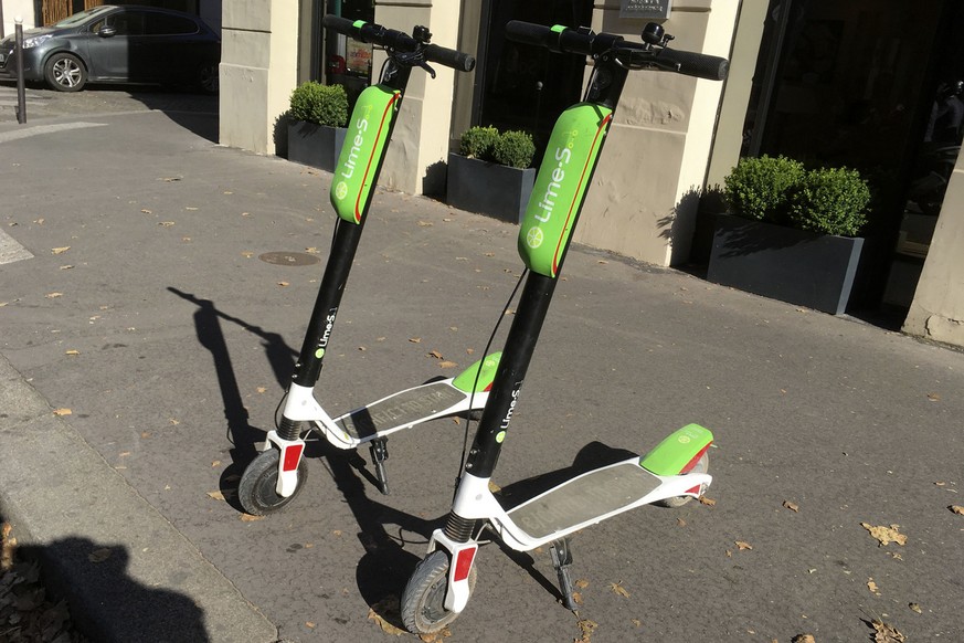 Arthur-Louis Jacquier director general of Lime France, right, and Jacky Song marketer and business developer ride a scooter in Paris, Wednesday, June 27, 2018. California-based bicycle sharing service ...