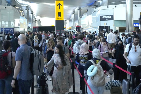 Travellers queue at security at Heathrow Airport in London, Wednesday, June 22, 2022. People face travelling disruption and long queues at airports amid the industry&#039;s ongoing staffing crisis. (A ...