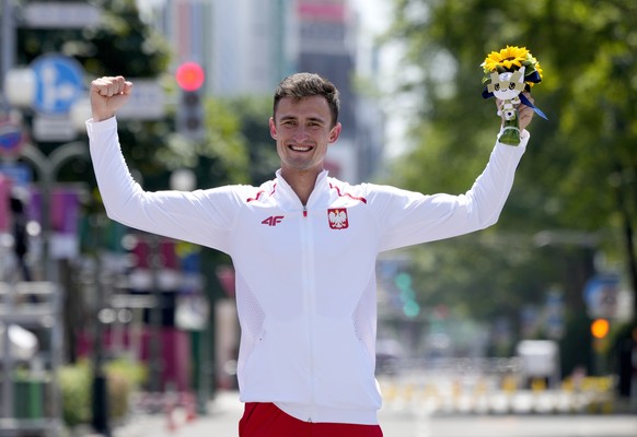 epa09399202 Gold medalist Dawid Tomala of Poland reacts during the flower ceremony for the Men&#039;s 50 kilometer Race Walk during the Athletics events of the Tokyo 2020 Olympic Games at the Odori Pa ...