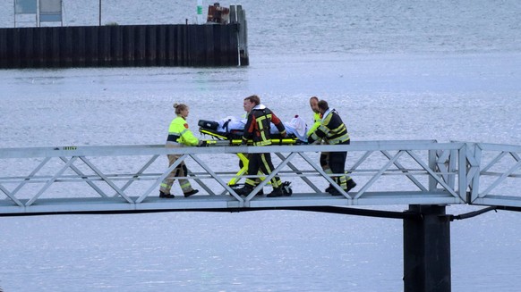 epa10768929 Emergency services bring a crew member of the Fremantle Highway cargo ship ashore in Lauwersoog, the Netherlands, 26 July 2023. A fire broke out overnight on 26 July on a freighter with 23 ...