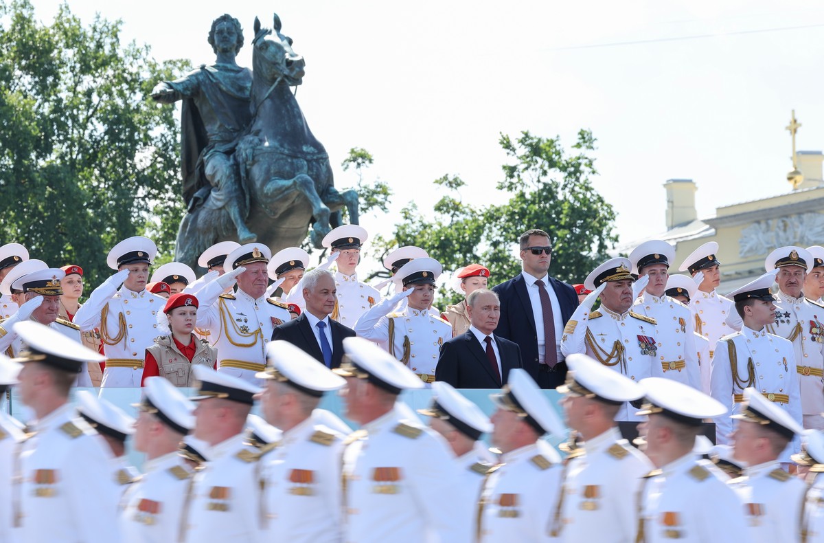 epa11502331 Russian President Vladimir Putin (C), Defence Minister Andrei Belousov and Commander-in-Chief of the Russian Navy Admiral Alexander Moiseev attend the annual Navy Day parade in St. Petersb ...