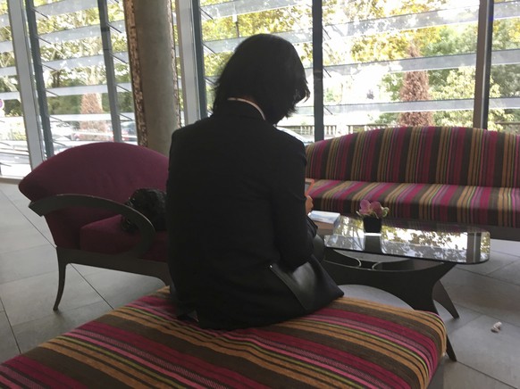 Grace Meng, the wife of missing Interpol President Meng Hongwei, who does not want her face shown, consults her mobile phone in the lobby of a hotel in Lyon, central France, where the police agency is ...