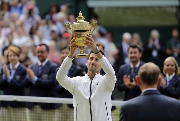 Serbia&#039;s Novak Djokovic lifts his trophy after defeating Switzerland&#039;s Roger Federer during the men&#039;s singles final match of the Wimbledon Tennis Championships in London, Sunday, July 1 ...